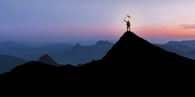 Силуэт бизнесмена стоя на вершине горы на фоне заката Сумерки с концепцией флаг, победитель, успех и лидерство