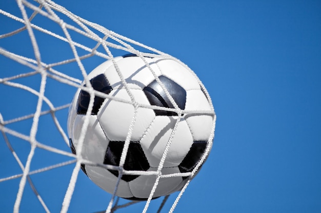 Фото Футбольный мяч в воротах. концепция футбола