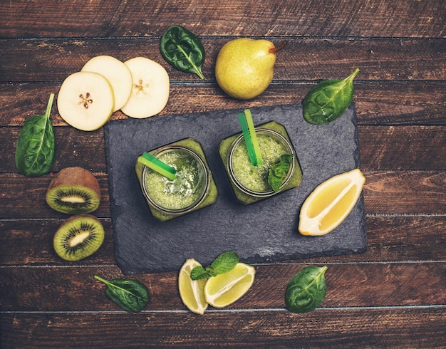 Смузи с авокадо, шпинатом, лаймом, киви и грушей в банке на сланце Концепция детоксикации здоровья и диеты