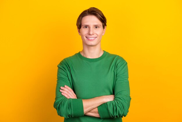 Фото Улыбающийся красивый мужчина в рубашке, стоящий со скрещенными руками на ярком цветном фоне