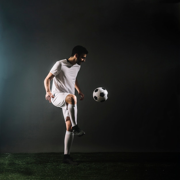Спортсмен, жонглирующий футбольный мяч