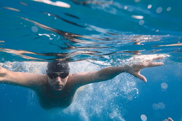 Спортивный человек быстро плавает в море