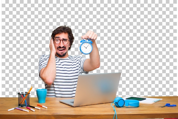 PSD young crazy graphic designer on a desk with a laptop and with an alarm clock