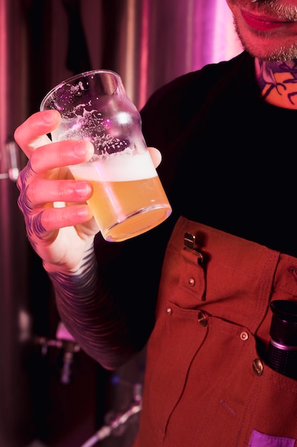 Gratis foto ambachtelijke bier concept met getatoeëerde man