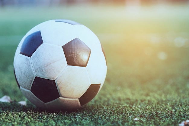 Gratis foto oud voetbal op het groene kunstmatige grasgebied - de concurrentie van het voetbal of van de voetbalspel