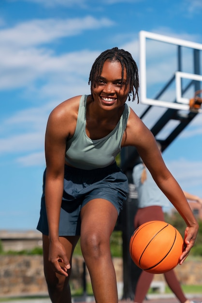 Gratis foto lage hoek vrouw training voor basketbal
