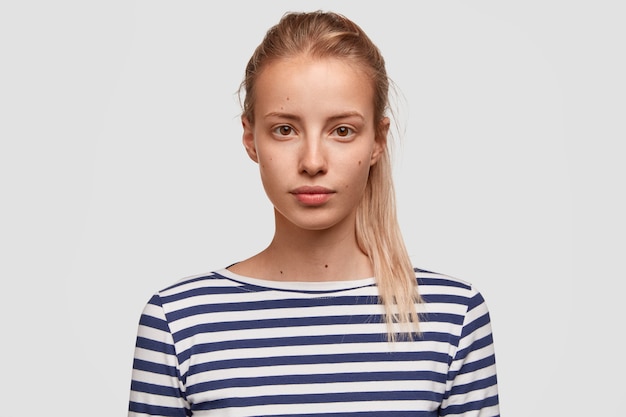 Gratis foto portret van een jonge vrouw die gestreepte blouse draagt