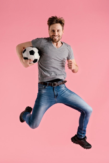 Gratis foto portret man springen bedrijf voetbal bal