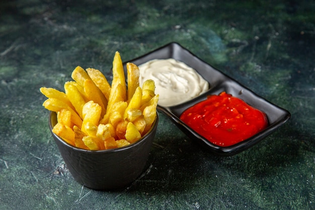 Gratis foto vooraanzicht heerlijke frietjes met kruiden op donkere ondergrond