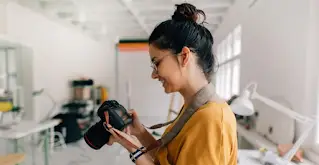 אישה מחייכת עם מצלמת DSLR.