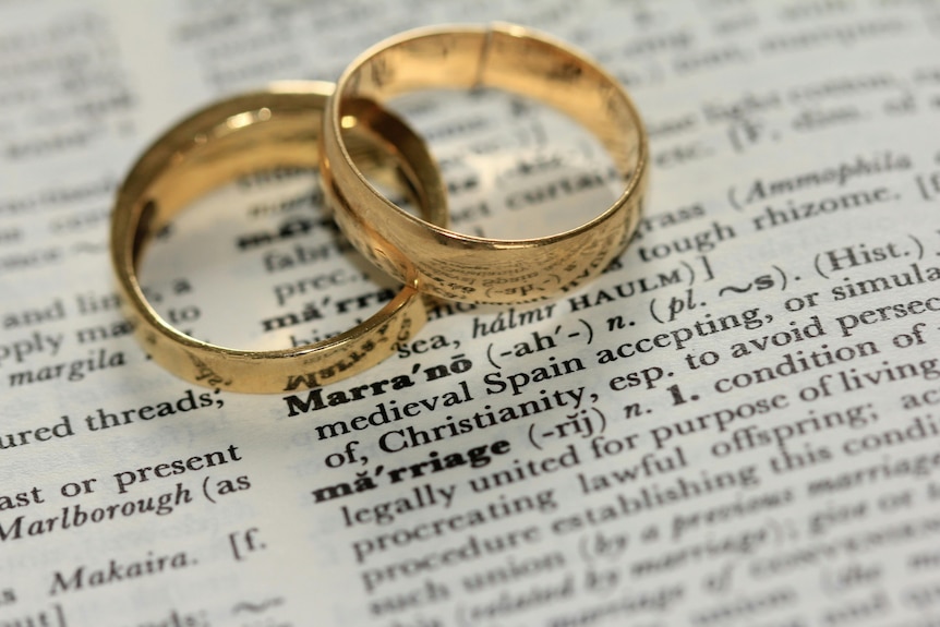 Two wedding bands resting on a book. 