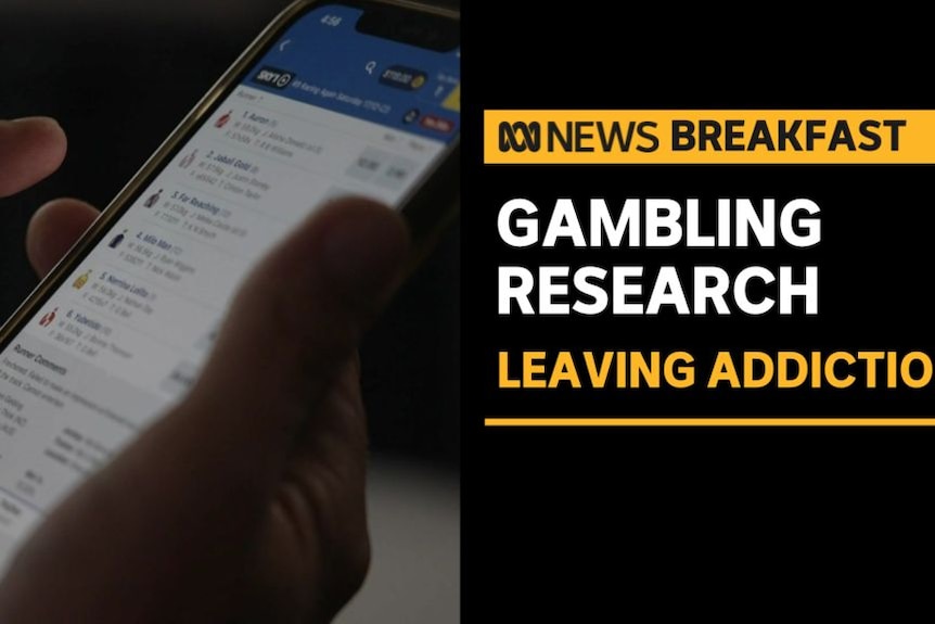 Gambling Research, Leaving Addiction: Hand holds phone scrolling through options on a betting website.