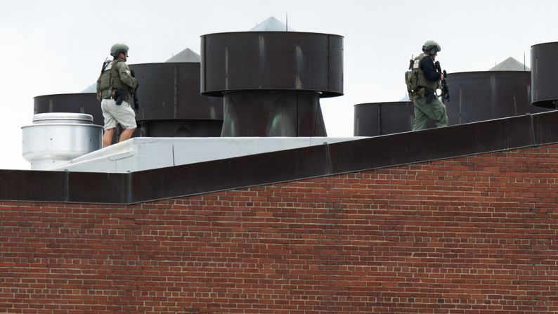 Police officers walk on a rooftop at the Washington Navy Yard after a <a href="http://www.cnn.com/2013/09/16/us/dc-navy-yard-gunshots/index.html"