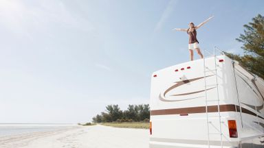 Woman standing on top of RV who needs RV camping tips