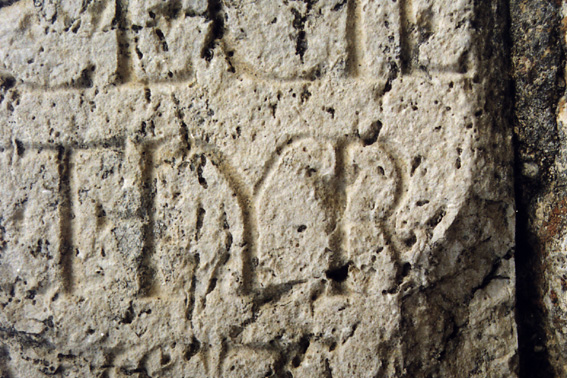 An extreme closeup of part of a Roman inscription, showing a ligatured TH.