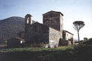 
[image ALT: A large old church, in a field with parasol pines, built on several arches of a Roman bridge: it is the church of S. Giovanni de Butris in Umbria (central Italy).]
			