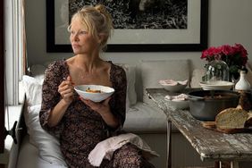 Pamela Anderson sitting at a table eating soup