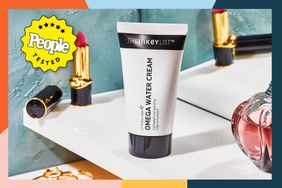 the inky list omega water cream tube sitting on vanity with lipstick and perfume