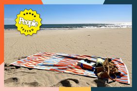 A colorful, patterned beach towel on the sand at the beach