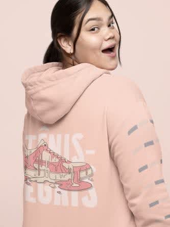 A plus-size woman with a surprised-happy expression mockup wearing a hoodie 