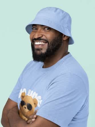 A smiling bearded black man mockup wearing a bucket hat and a t-shirt while posing at a studio 