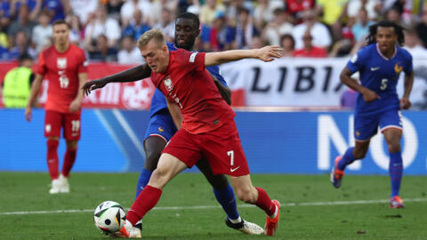 France's defender Dayot Upamecano tackles Poland's forward Karol Swiderski during the UEFA Euro 2024 Group D football match between France and Poland in Germany on June 25, 2024.