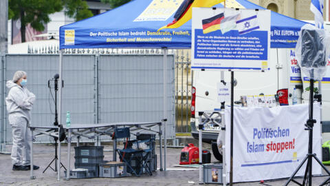 A forensic police officer walks past a smashed stall of Pax Europa which had a banner with writing reading "Stop political Islam", on the market square in Mannheim, Germany on May 31, 2024. 