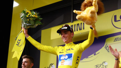 Romain Bardet, del equipo dsm-firmenich PostNL, celebra en el podio con el maillot amarillo tras ganar la etapa 1.
