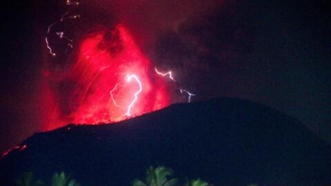 Lightning strikes as lava erupts from the crater of Mount Ibu, as seen from West Halmahera, North Maluku