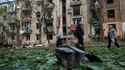 Местные жители возле жилого дома, поврежденного в результате российского авиаудара в Харькове, Украина, 5 мая 2024 года.