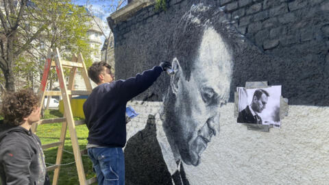 Австрийские художники рисуют портрет Алексея Навального на стене за памятником советским солдатам в Вене. 27 марта 2024