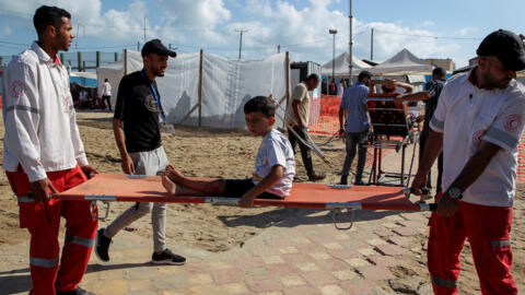 Equipa de socorros transporta criança palestiniana ferida durante um bombardeamento israelita, em Rafah, sul da Faixa de Gaza, a 30 de Maio de 2024. 