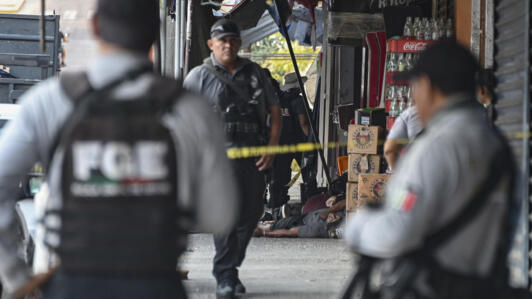 Les enquêteurs du bureau du procureur, de la police d'État et du personnel médico-légal travaillent sur une scène de crime où cinq personnes ont été assassinées dans un marché artisanal lors d'une vague de violence qui a frappé le port touristique d'Acapulco, dans l'État de Guerrero, au Mexique, le 23 mai 2024.