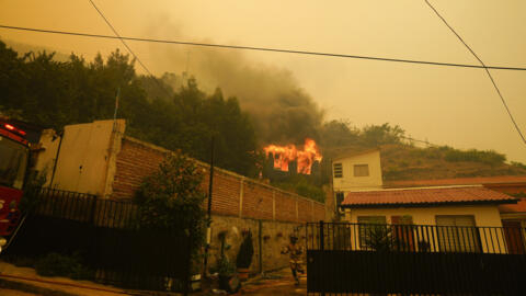 Un pompier traverse une cour alors qu'un bâtiment prend feu à Vina del Mar, au Chili, le samedi 3 février 2024.