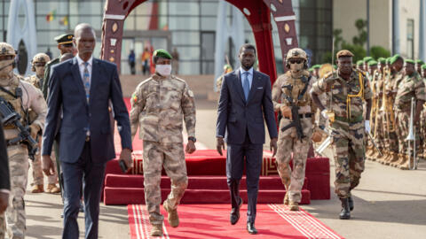 Le président sénégalais Bassirou Diomaye Faye marche aux côtés du chef de la junte malienne Assimi Goita, à Bamako, au Mali, le 30 mai 2024.