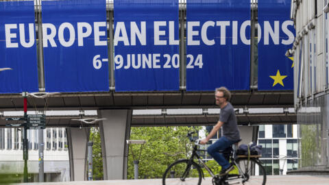Homem passa de bicicleta em frente ao Parlamento Europeu, em Bruxelas.