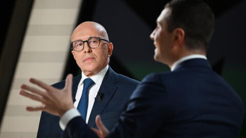 French conservative party Les Republicains (LR) President Eric Ciotti (L) looks at French far-right Rassemblement National (RN) party President Jordan Bardella (R) speaking during a debate as part of 