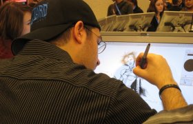 En animatør sit foran ein skjerm og teiknar.