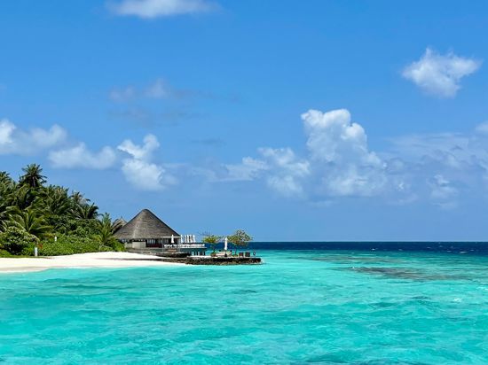 Türkises Wasser, blauer Himmel, weißer Sand, grüne Palmen: Dieser Blick im Huvafen Fushi fasst gut zusammen, warum die Malediven für viele ein Sehnsuchtsziel sind.