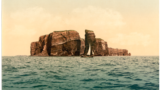 Postkarte: Hohe Felsen im Meer, davor ein Fischerboot.