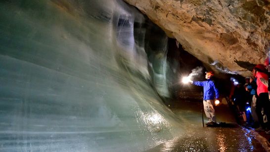 Menschen begutachten eine Eiswand in der Schellenberger Eishöhle.