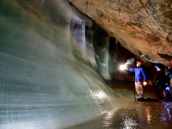 Menschen begutachten eine Eiswand in der Schellenberger Eishöhle.